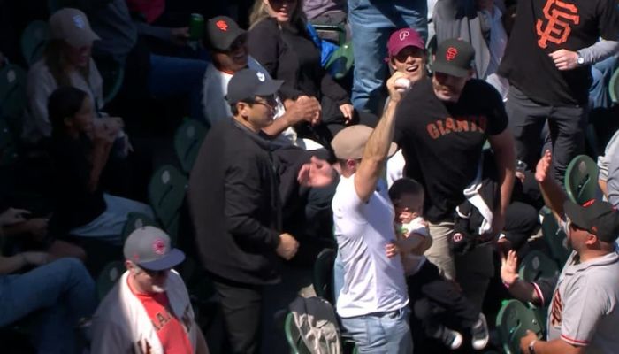 giants fan catches foul with baby in other arm